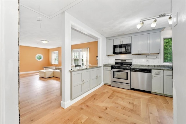 825 S St, Tewksbury, MA 01876 - kitchen with appliances with stainless steel finishes, tasteful backsplash, healthy amount of natural light, and light stone counters
