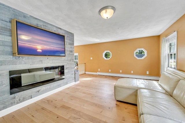 825 S St, Tewksbury, MA 01876 - living room with baseboard heating, wood finished floors, baseboards, and a stone fireplace