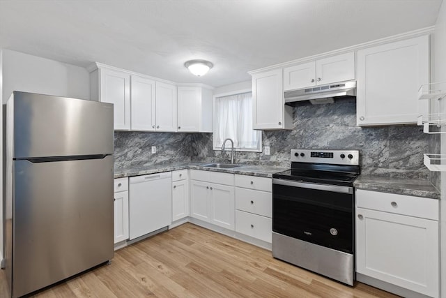 kitchen featuring white cabinets, sink, light wood-type flooring, tasteful backsplash, and stainless steel appliances