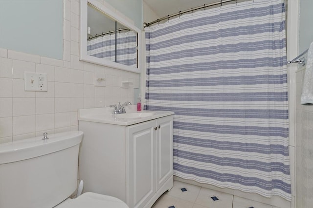 bathroom with tile walls, vanity, toilet, and a shower with shower curtain