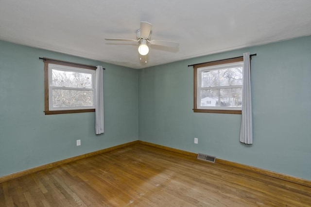 spare room with ceiling fan, plenty of natural light, and light hardwood / wood-style flooring