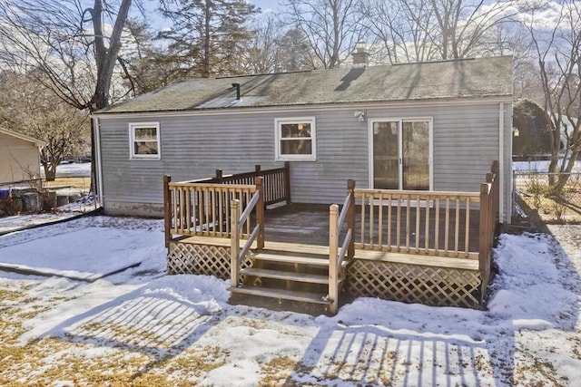 snow covered rear of property featuring a deck