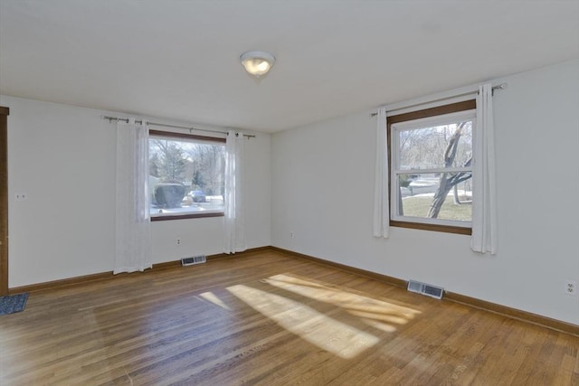 spare room with a healthy amount of sunlight and wood-type flooring