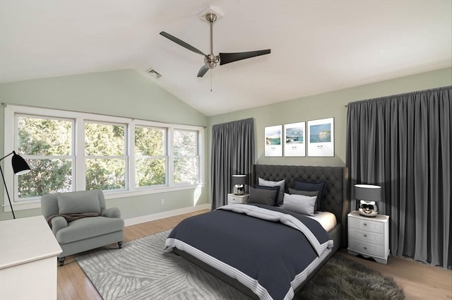 bedroom featuring lofted ceiling, ceiling fan, visible vents, baseboards, and light wood-type flooring