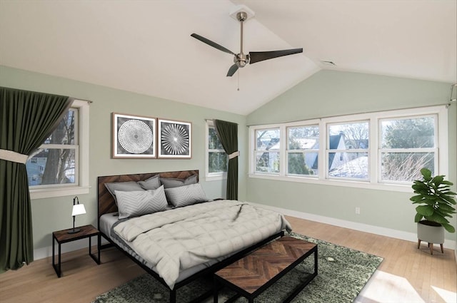 bedroom with light wood finished floors, visible vents, baseboards, ceiling fan, and vaulted ceiling