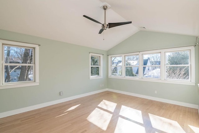 unfurnished room featuring vaulted ceiling, light wood-style flooring, and baseboards