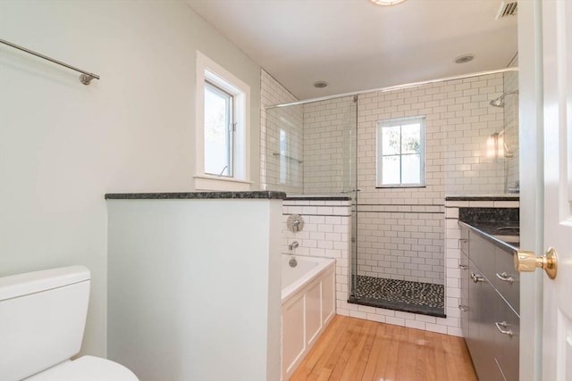 bathroom with toilet, a shower stall, visible vents, and a healthy amount of sunlight