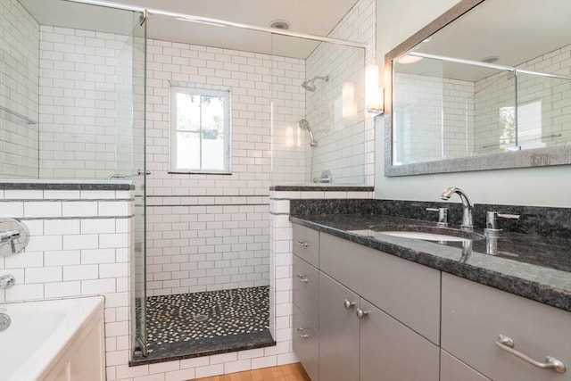 bathroom with a stall shower, a garden tub, and vanity