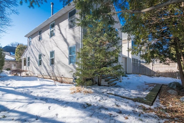 view of snow covered exterior with fence