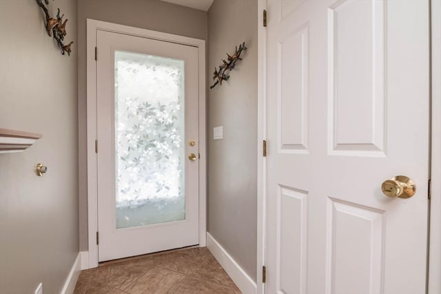 entryway with baseboards and light tile patterned floors