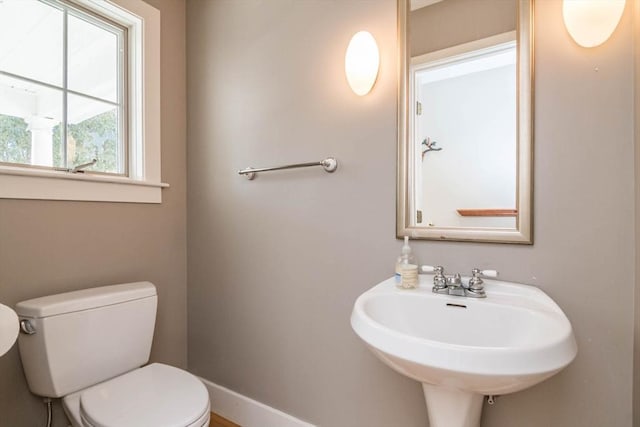 bathroom with baseboards, a sink, and toilet