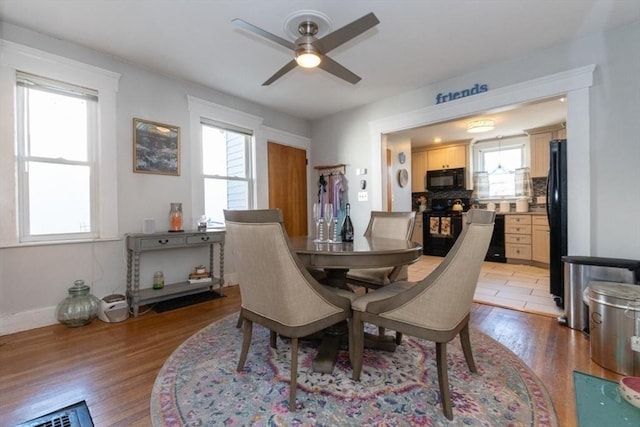 dining area with a ceiling fan, light wood-style floors, and baseboards