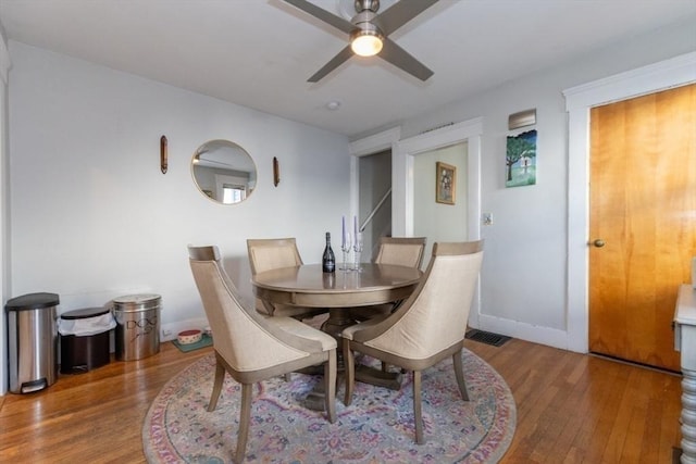 dining area with ceiling fan, visible vents, baseboards, and wood finished floors