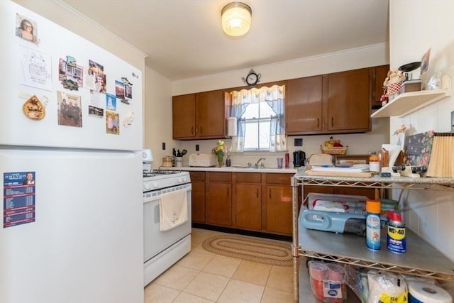 kitchen featuring crown molding, light countertops, brown cabinets, white appliances, and a sink