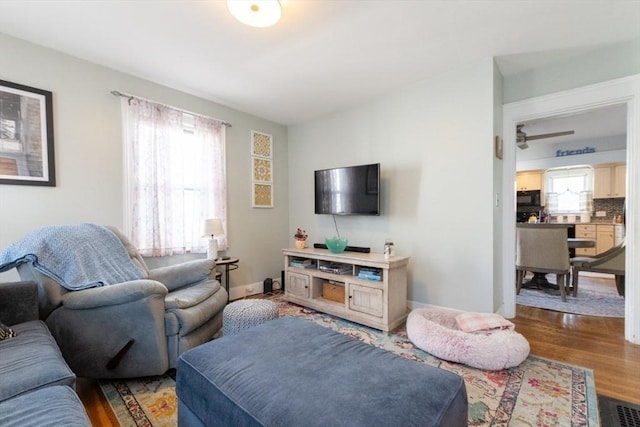 living area with visible vents, wood finished floors, and baseboards