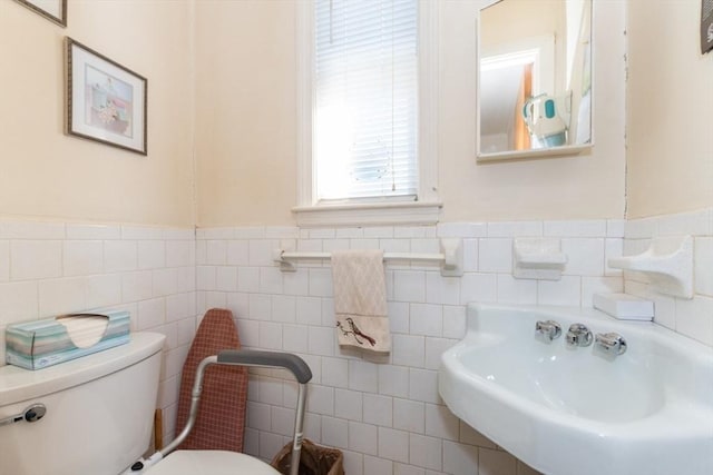 bathroom with wainscoting, toilet, and a sink