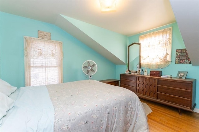 bedroom featuring lofted ceiling and wood finished floors