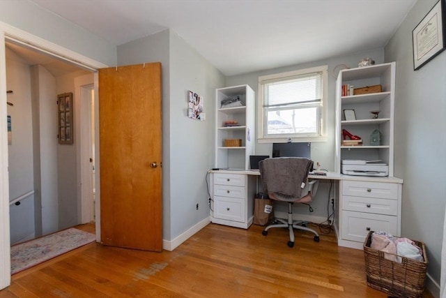 office area featuring baseboards and light wood-type flooring