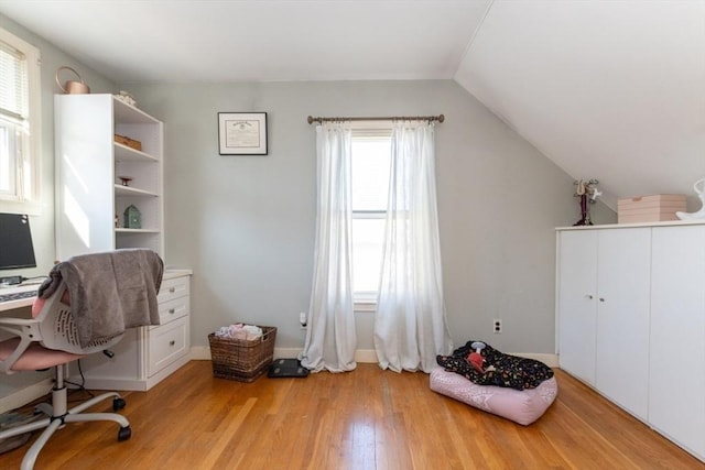 home office with lofted ceiling and light wood finished floors