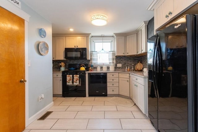 kitchen featuring tasteful backsplash, visible vents, black appliances, and baseboards