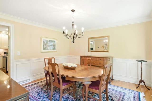 34 Hawks Cir, Westfield, MA 01085 - dining room featuring a chandelier, crown molding, light wood-style floors, wainscoting, and a decorative wall