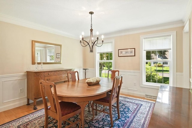 34 Hawks Cir, Westfield, MA 01085 - dining space featuring a chandelier, a wainscoted wall, ornamental molding, a decorative wall, and light wood-type flooring