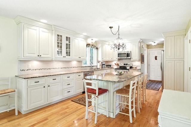 34 Hawks Cir, Westfield, MA 01085 - kitchen featuring stainless steel appliances, a kitchen bar, light wood-style floors, a center island, and tasteful backsplash