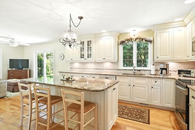 34 Hawks Cir, Westfield, MA 01085 - kitchen with stainless steel appliances, open floor plan, light wood finished floors, tasteful backsplash, and light stone countertops