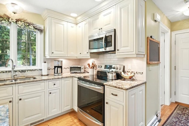 34 Hawks Cir, Westfield, MA 01085 - kitchen featuring appliances with stainless steel finishes, light wood-style flooring, decorative backsplash, and light stone countertops