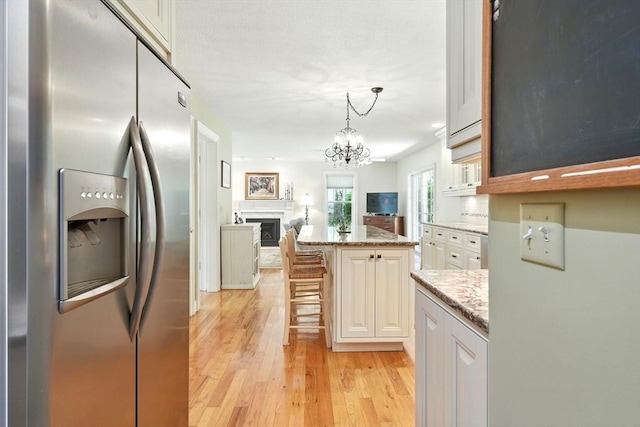 34 Hawks Cir, Westfield, MA 01085 - kitchen with stainless steel refrigerator with ice dispenser, open floor plan, light wood finished floors, a chandelier, and light stone countertops