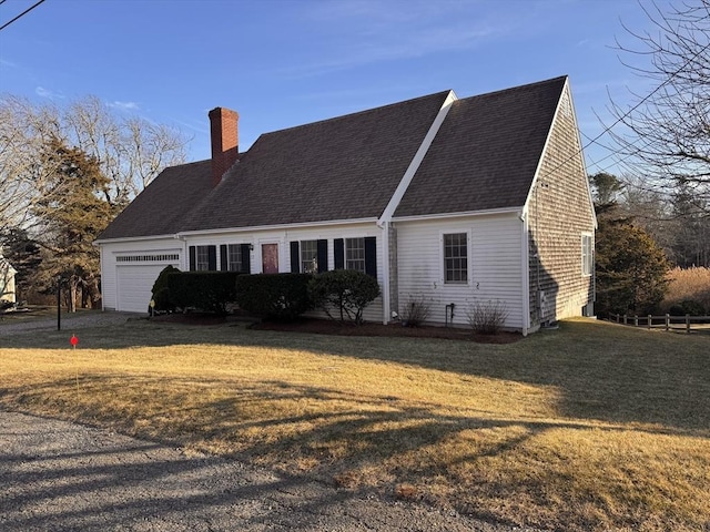 view of side of home with a yard, a chimney, an attached garage, and roof with shingles