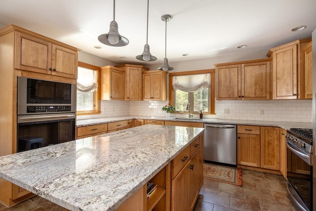 kitchen featuring a sink, appliances with stainless steel finishes, backsplash, and a kitchen island