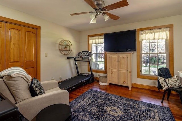 workout room featuring baseboards, a ceiling fan, and wood finished floors
