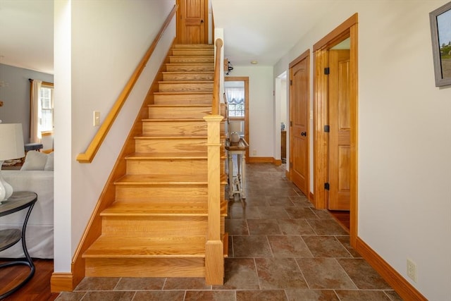 stairs with baseboards and stone finish flooring