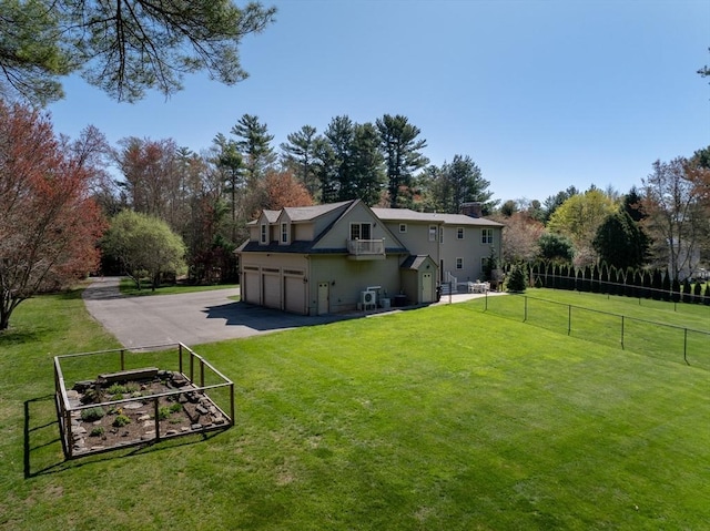 back of property with a lawn, fence, driveway, and a garage