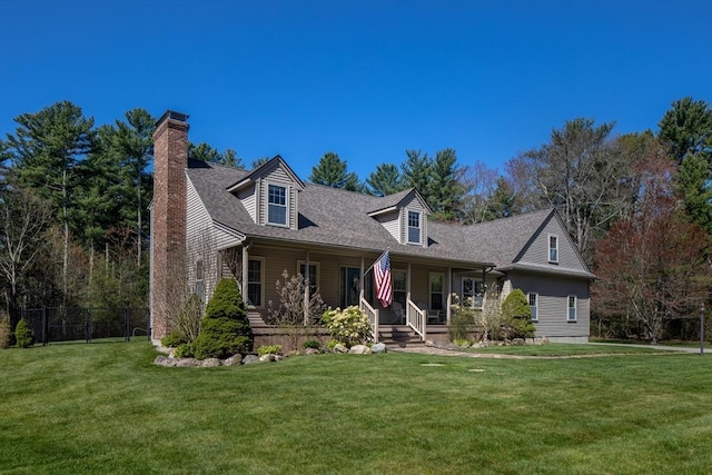 new england style home featuring fence, a chimney, a porch, and a front yard