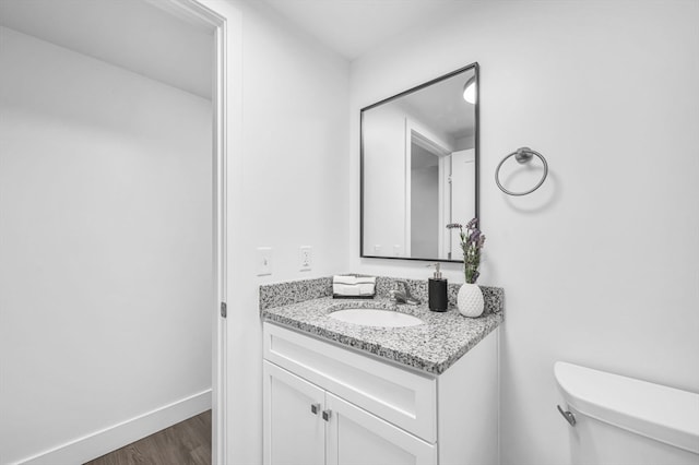 bathroom featuring hardwood / wood-style flooring, vanity, and toilet