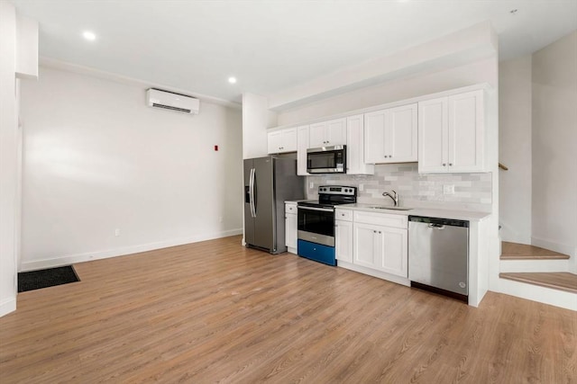 1280 Middlesex St Unit 2, Lowell, MA 01851 - kitchen with appliances with stainless steel finishes, a sink, a wall unit AC, light countertops, and backsplash