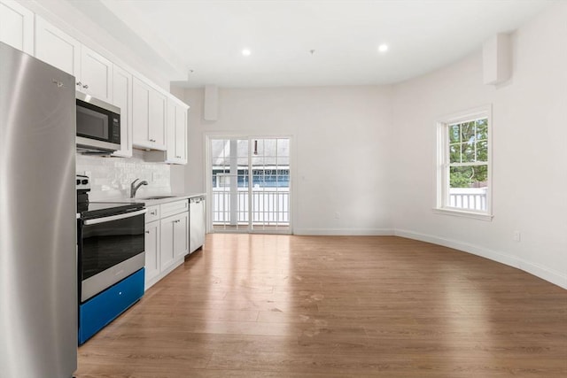 1280 Middlesex St Unit 2, Lowell, MA 01851 - kitchen with stainless steel appliances, light wood-style floors, white cabinetry, recessed lighting, and decorative backsplash