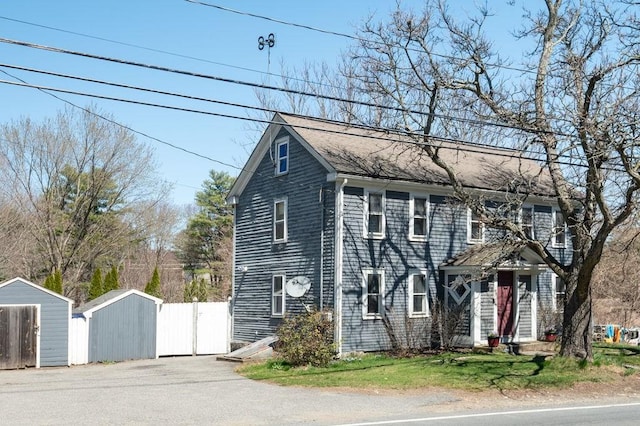 231 W Main St, Georgetown, MA 01833 - colonial inspired home featuring a storage unit, an outbuilding, fence, and a shingled roof