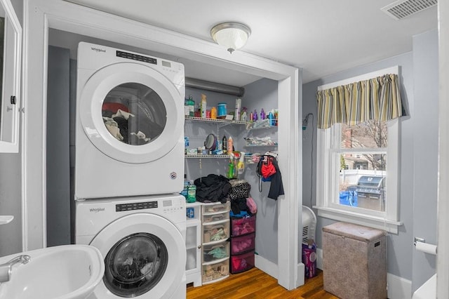 231 W Main St, Georgetown, MA 01833 - washroom featuring stacked washer and clothes dryer, wood finished floors, and baseboards