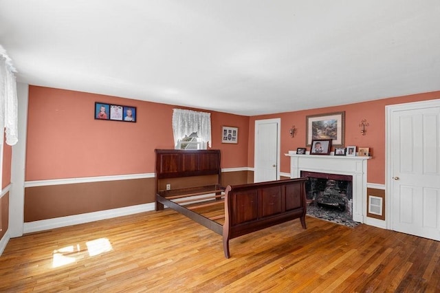 231 W Main St, Georgetown, MA 01833 - bedroom with light wood-type flooring, a premium fireplace, and baseboards
