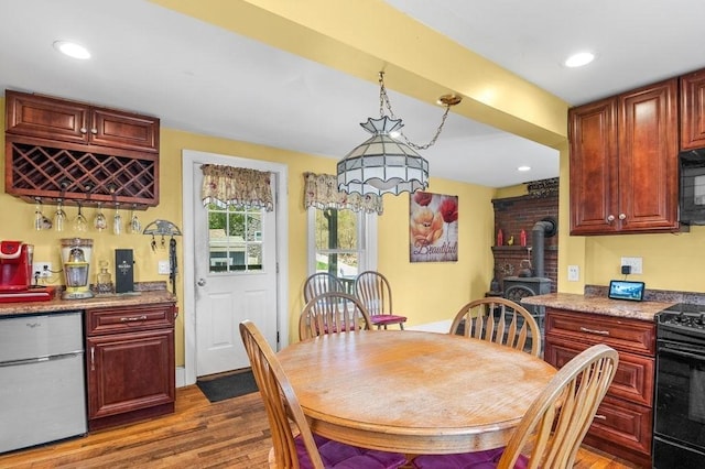 231 W Main St, Georgetown, MA 01833 - dining area featuring a wood stove, dark wood-style flooring, a dry bar, and recessed lighting