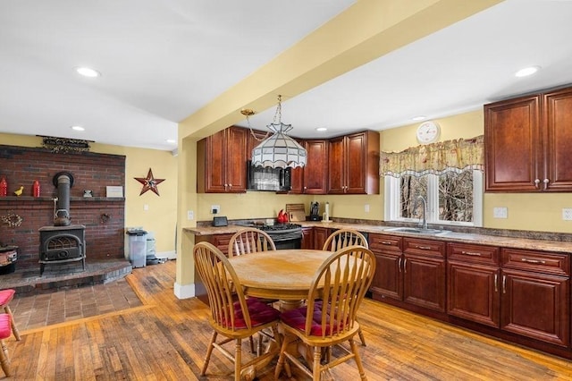231 W Main St, Georgetown, MA 01833 - kitchen featuring a sink, wood finished floors, a wood stove, black electric range oven, and recessed lighting