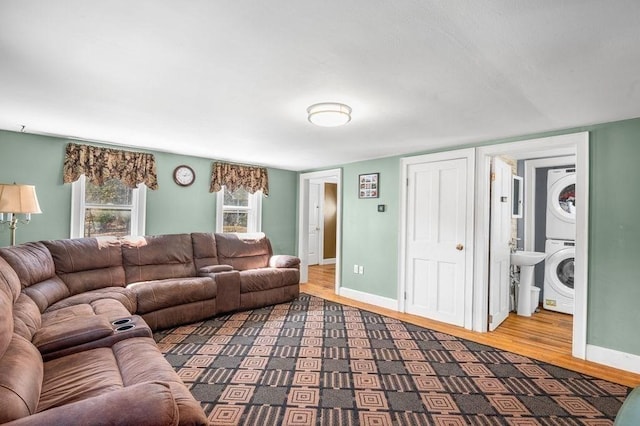 231 W Main St, Georgetown, MA 01833 - living room featuring stacked washer and clothes dryer, wood finished floors, and baseboards