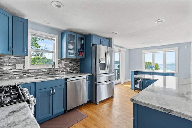 70 Williams St, Quincy, MA 02171 - kitchen featuring appliances with stainless steel finishes, blue cabinets, tasteful backsplash, glass insert cabinets, and recessed lighting