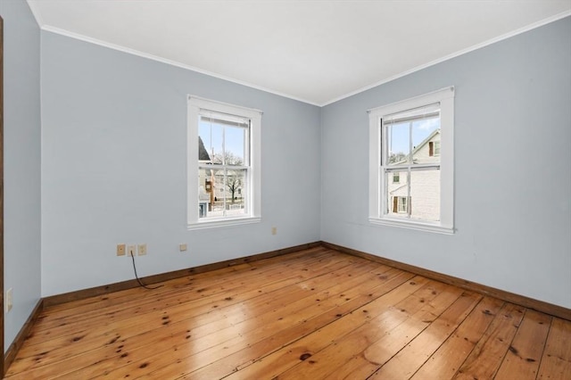 spare room featuring light wood finished floors, baseboards, and ornamental molding