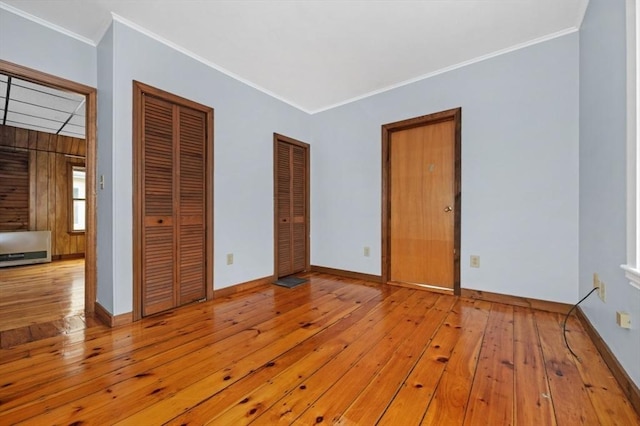 interior space featuring baseboards, hardwood / wood-style floors, and crown molding