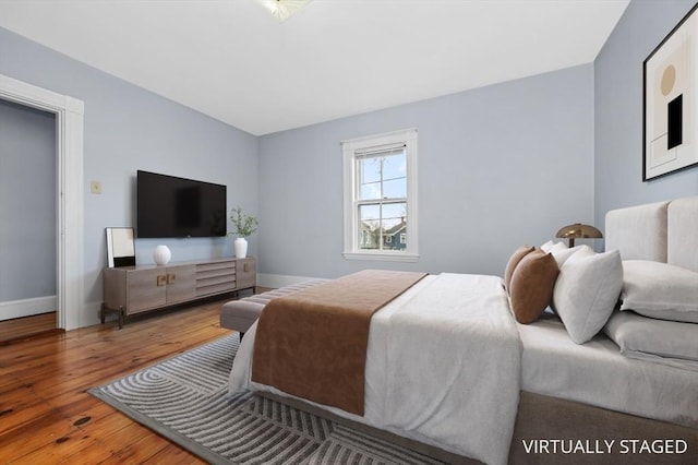 bedroom featuring wood finished floors and baseboards