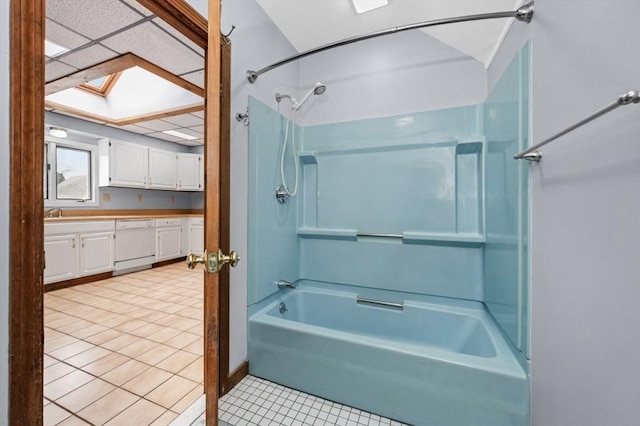 bathroom with a skylight, washtub / shower combination, vanity, and tile patterned floors